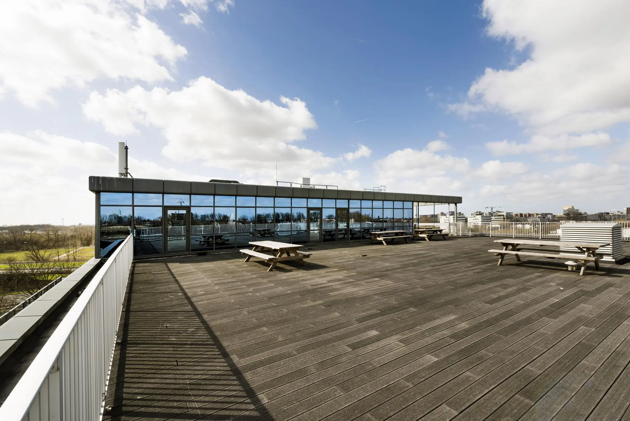 Ruim dakterras met houten picknicktafels bij een modern kantoorgebouw aan de Anthony Fokkerweg.